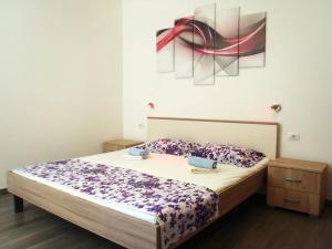 a bed in a bedroom with a painting on the wall at Apartment Ella in Split