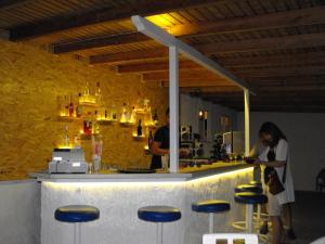 two women standing in front of a bar with stools at Le Mirage Hotel in Benitses