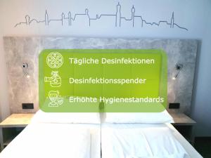 a sign on top of a bed in a room at SleepySleepy Hotel Dillingen in Dillingen an der Donau