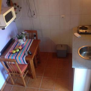 uma pequena cozinha com uma mesa e um micro-ondas em Solar de Rabal em Bragança