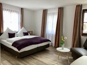 1 dormitorio con 1 cama grande y 1 sofá en A Lotus Hotel, en Böblingen