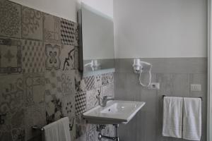 a bathroom with a sink and a mirror and towels at La Guitgia Rooms in Lampedusa