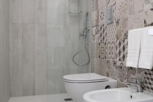 a bathroom with a shower and a toilet and a sink at La Guitgia Rooms in Lampedusa
