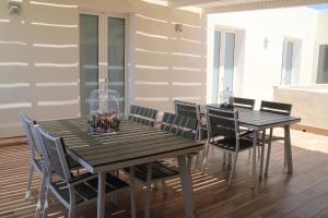 a dining room with two wooden tables and chairs at La Guitgia Rooms in Lampedusa