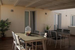 a dining room with a wooden table and chairs at La Guitgia Rooms in Lampedusa