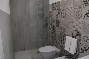a small bathroom with a toilet and a shower at La Guitgia Rooms in Lampedusa