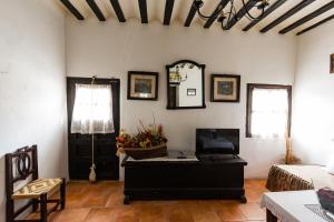 a living room with a tv and a couch and a table at La Casa de los Soportales in Chinchón