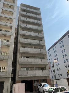 een hoog gebouw met auto's ervoor geparkeerd bij 豊水すすきの駅から徒歩数分 IK Minami 6 Jo Residence 101 IK南6条レジデンス in Sapporo