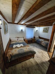 a bedroom with two beds in a room with wooden ceilings at Kashtata s Paraklisa in Borowo