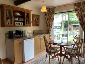 a kitchen with a table and a table and chairs at Brookleys in Bidford