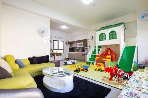 ein Wohnzimmer mit einem gelben Sofa und einem Spielset in der Unterkunft J.S 23 in Kaohsiung