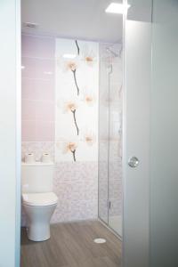 a bathroom with a toilet and a glass shower at Tomás Guest House in Covilhã