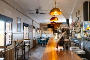 a restaurant with a bar with tables and chairs at Hostal El Trillero in Alcañiz
