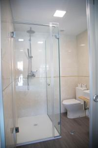 een badkamer met een douche en een toilet bij Tomás Guest House in Covilhã