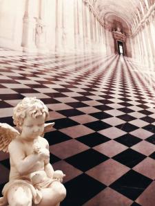 a statue of an angel sitting on a checkered floor at Pokoje Mrągowo in Mrągowo