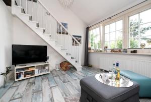 a living room with a tv and a staircase at Kirchenweg App15 in Westerland (Sylt)