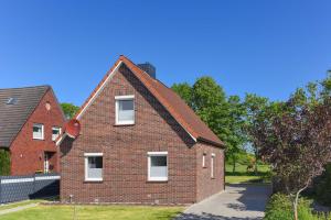 a red brick house with a gambrel roof at Ferienhaus Nordseeliebe in Esens
