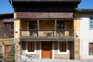 una casa antigua con un balcón en el lateral. en La Escanda en La Rebollada