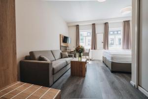 a living room with a couch and a bed at Hotel Restaurant Roemer in Merzig