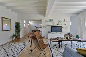 ein Wohnzimmer mit Stühlen, einem Tisch und einem TV in der Unterkunft Scheldewegel Vakantiehuis in Schelderode