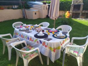 una mesa blanca con sillas y una mesa con comida. en pension trescasas, en Trescasas