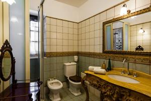 ein Badezimmer mit Toilette, Waschbecken und Spiegel in der Unterkunft Villa Rubino in Catania + 16 Fotos