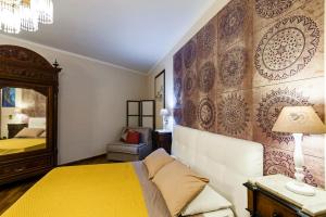 ein Schlafzimmer mit einem gelben Bett und einem Spiegel in der Unterkunft Villa Rubino in Catania