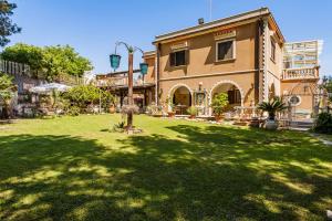 ein großes Haus mit einem Garten mit einem Rasengarten sidx sidx sidx in der Unterkunft Villa Rubino in Catania