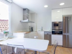 une cuisine blanche avec une table et des chaises blanches dans l'établissement Mundaka by Aston Rentals, à Mundaka