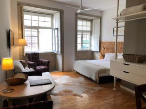波多的住宿－波爾圖森斯濱河公寓，一间卧室配有一张床、一张桌子和一张桌子