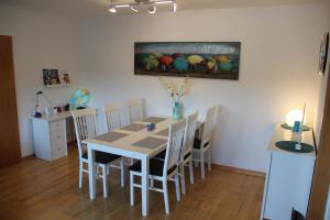 a dining room table with chairs and a painting on the wall at Altstadtflair in Stolberg