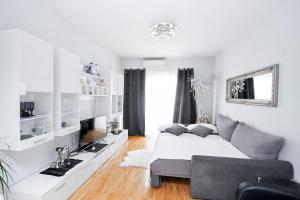 a white bedroom with a bed and a couch at Villa Norah in Podgora