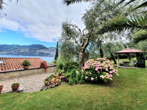a garden with pink flowers and a gazebo at Casa Valenti in Brenzone sul Garda