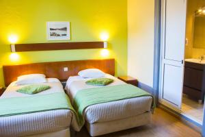 two beds in a small room with yellow walls at Hotel Estoril Porto in Porto