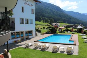 hotel z basenem obok budynku w obiekcie Hotel Lindnerhof w mieście San Lorenzo di Sebato