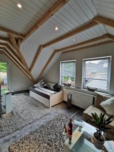 un soggiorno mansardato con un letto e due finestre di Apartments Margaretenhof a Wilhelmshaven