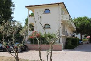 a large white building with a tree in front of it at Villetta Tina in Vada