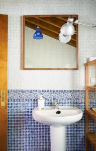 ein Badezimmer mit einem weißen Waschbecken und einem Spiegel in der Unterkunft San Pedro Villoria in Pola de Laviana