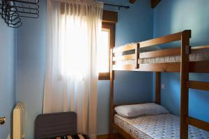 1 Schlafzimmer mit 2 Etagenbetten und einem Fenster in der Unterkunft San Pedro Villoria in Pola de Laviana