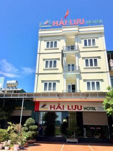 ein großes weißes Gebäude mit einem Schild darüber in der Unterkunft Hải Lưu Hotel in Cái Rồng