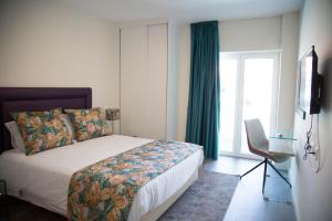 a hotel room with a bed and a window at Tomás Guest House in Covilhã