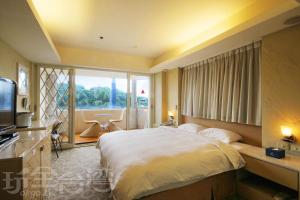 a bedroom with a large bed and a large window at Blue Ocean Hotel in Keelung