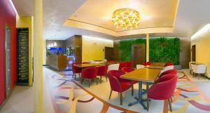 a restaurant with red chairs and tables in a room at Hotel Air in Holíč