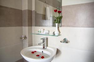a bathroom with a sink and a vase with flowers at Poetic Hue Hotel & Spa in Hue