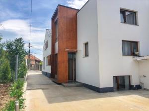 an external view of a white house with a wooden facade at InnTime in Cluj-Napoca