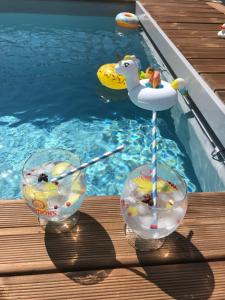 una piscina con due bicchieri e un cigno giocattolo in una piscina di MappaMundo a Ribamar