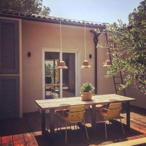 einen Holztisch und Stühle auf einer Terrasse in der Unterkunft La Grechea Boutique B&B in Casale Alxi