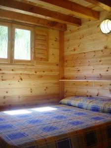 Camping Vall de Ribes في ريب دي فريزر: كابينة خشب مع سرير في الغرفة