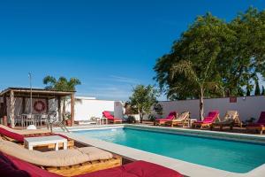 a swimming pool with chaise lounges and chairs around it at Villa Mayo con piscina privada in Conil de la Frontera