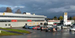 un estacionamiento con autos estacionados frente a un edificio en Vormsund Golf Hotell, en Vormsund